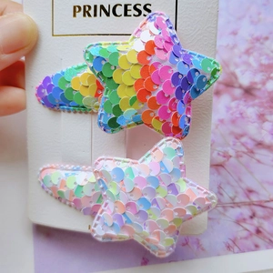 Close-up of two star hair clips with iridescent sequins and glitter on Princess card