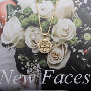 Collana con medaglia di San Benedetto dorata con zirconi su sfondo decorativo