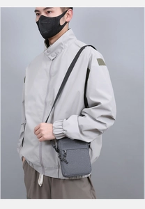Detailed close-up of a grey crossbody bag worn by a model for a stylish outdoor travel look