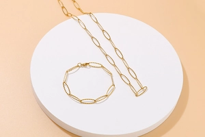 Close-up of gold stainless steel necklace and bracelet set with hollow oval links