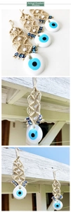 Detail of Turkish Evil Eye wall hanging with woven rope and blue eye beads decor