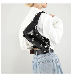 Close-up of black hobo bag with large silver ball studs shown on model shoulder
