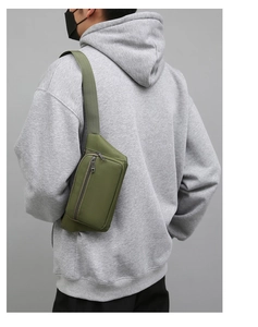 Olive green nylon waist bag shown from a back-view perspective on a grey sweatshirt