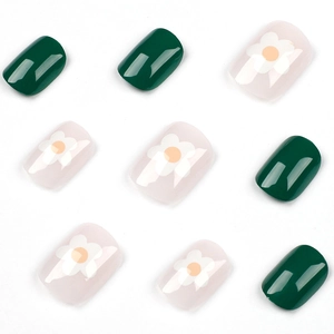 Short round green press-on nails with white flower patterns and glossy finish