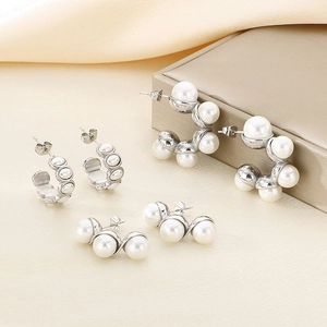 Minimalist C-shaped stainless steel earrings with elegant white pearls on silk