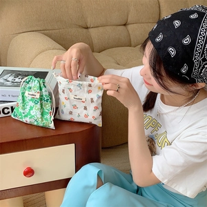 Close-up of floral and bear print cotton drawstring bags with dual cord closure