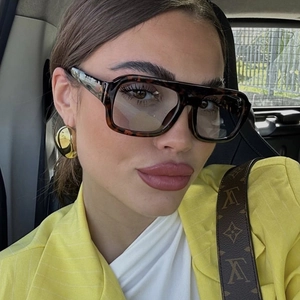 Fashionable tortoise shell oversized square sunglasses worn by a model in a yellow suit