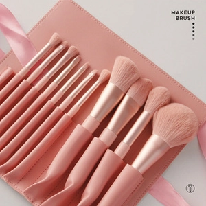 Detail of professional 10-piece makeup brush set with elegant pink leather roll bag case