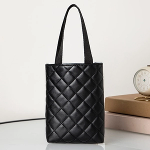 Classic black quilted tote bag with soft leather texture on a minimalist display