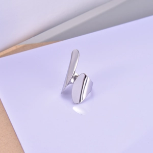 Macro shot of minimalist silver open ring with dual irregular leaf-shaped metal pieces