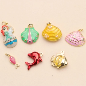Detail of colorful enamel marine charms including mermaid and shells with gold metal finish