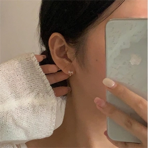 Elegant 925 silver bow earrings with zircon stones worn in a minimalist Korean style