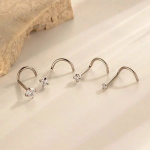 Titanium F136 nose studs with round zircon stones on a natural stone background
