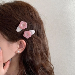 Pink acrylic flower hair clips with marble texture shown on a female model