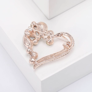 Detail of rose gold heart brooch with safety pin clasp and delicate crystal inlay