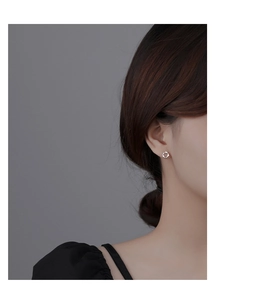 Close-up of a silver floral wreath earring with shimmering crystals on a model