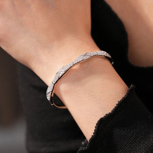 Detailed view of silver quilted bangle with pavé zircons worn on a model's wrist
