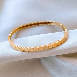 Macro view of gold honeycomb textured titanium steel bracelet with a hexagonal pattern