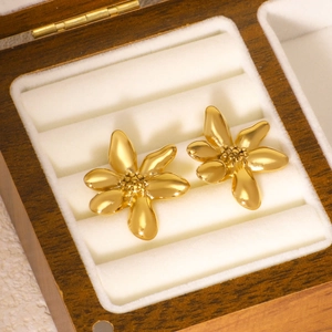 Golden stainless steel six-petal flower stud earrings displayed in a luxury jewelry box