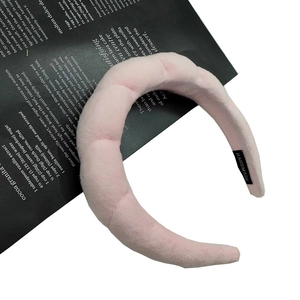 Detailed close-up of pink velvet padded headband with handmade craft label on side