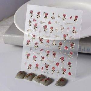 Macro shot of 3D embossed red rose nail art stickers with golden leaves on white background