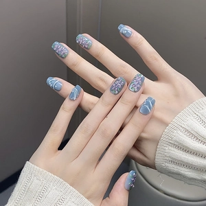 Detail of blue-grey press-on nails featuring white lines and purple floral hand-painted art