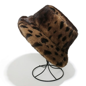 Brown leopard print faux fur bucket hat displayed on a sleek black metal wire stand