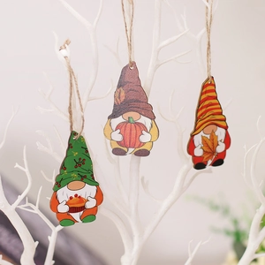 Three wooden harvest gnomes hanging on branch with pumpkin and maple leaf decor