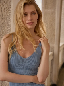Close-up of light blue knitted fabric texture on V-neck sleeveless summer dress