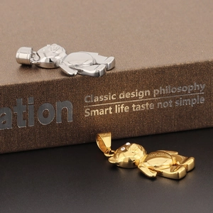 Macro shot of gold and silver panda pendants with rhinestones on a classic book edge