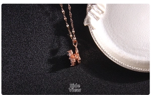 Detailed side view of rose gold four-leaf clover pendant with zircon inlay and chain