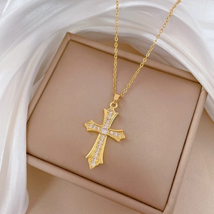 Luxurious gold titanium cross necklace with sparkling cubic zirconia on a gift box