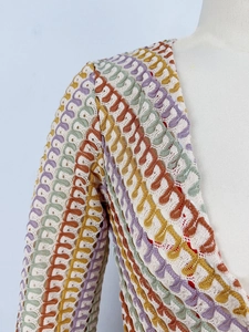 Dettaglio di un abito all'uncinetto colorato con scollo a V e motivo a maglia a onde