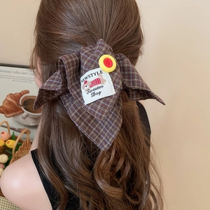Detail of checkered fabric dachshund hair clip with yellow button and dog label