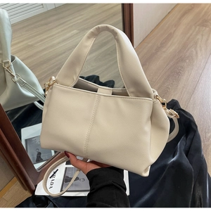 Detailed shot of beige lychee texture faux leather bag with elegant pleated design