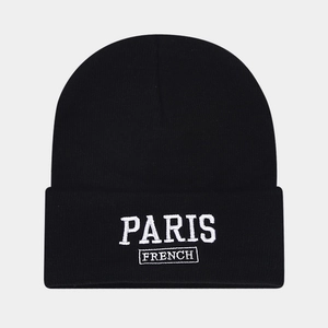 Close-up of white Paris French embroidery on black knitted beanie with textured detail