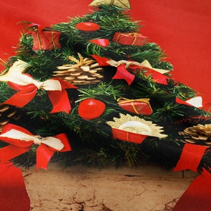 Dettaglio dell'arazzo natalizio con motivi di alberi di Natale e fiocchi rossi