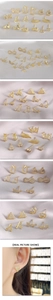 Detailed close-up of gold geometric stud earring set with zircons on silk fabric