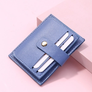 Close-up of light blue litchi pattern leather card holder with gold snap button detail