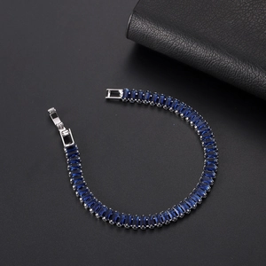 Close-up of deep blue rectangular cut zircon tennis bracelet with silver-tone plating