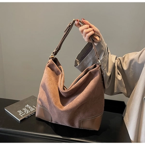 Macro view of brown vintage suede tote bag showing material texture and leather details
