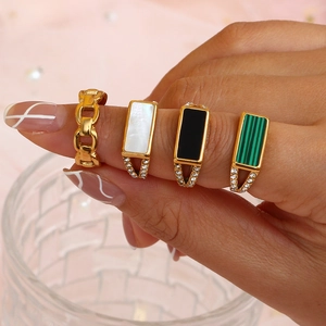 Set of four gold-plated stainless steel rings featuring side diamonds and retro square inlays