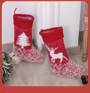 Close-up of knit Christmas stockings with reindeer and tree patterns in festive setting