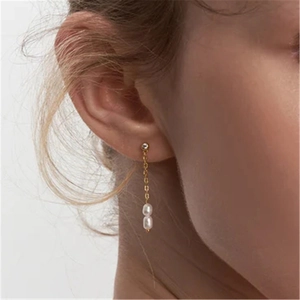 Long S925 sterling silver tassel earrings with elegant white pearls on a model