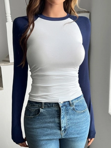 Dettaglio di una maglia a maniche lunghe raglan bianca e blu navy in stile Y2K da donna