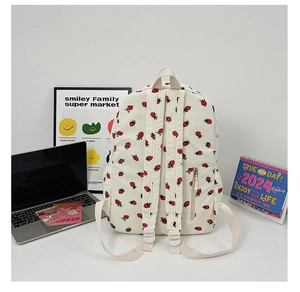 Detail of off-white corduroy backpack with strawberry print and side zipper pocket