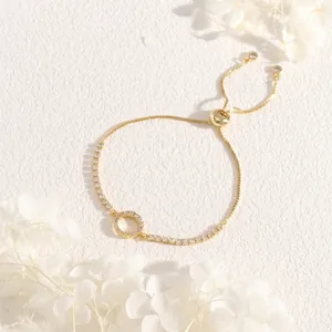 Detail of adjustable gold slider bracelet with sparkling zircon ring and snake chain
