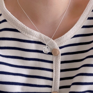 Close-up of a 925 sterling silver necklace with irregular round textured pendant on a model