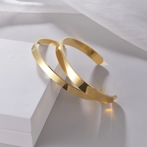 Bracelets joncs dorés minimalistes en acier inoxydable sur support géométrique