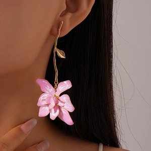 Detailed close-up showing pink floral drop earrings worn on a model with golden stems